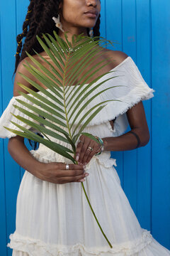 female hands holding green palm leaf, eco-friendly fashion, closeup
