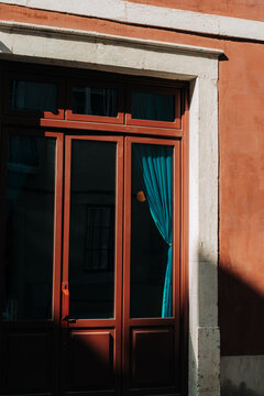 Sunlit vintage doorway with turquoise curtains and terracotta fa