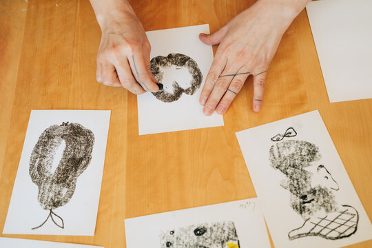Close-up of artist hands creating charcoal drawing on paper