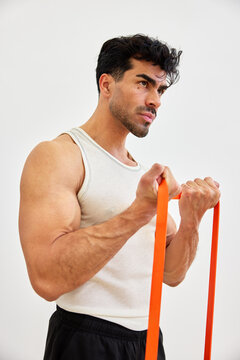 Man trains with resistance bands in indoor gym setting