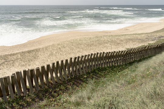 Minimal coastal shoreline with wooden fence and ocean waves