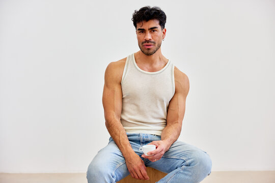 Man sits calmly holding cup in light room