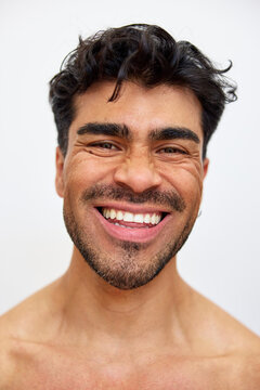Man smiling with teeth showing in a simple background