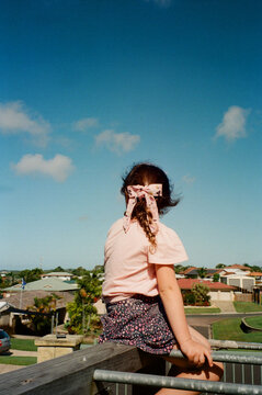 Young girl sitting on top of monkey bars in Australian Front Yard.