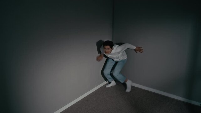 Portrait of middle aged Caucasian woman with mental disorder cowering in corner, then running towards camera and reaching out frantically. Clip is ideal for mental health awareness campaigns