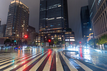 Obraz premium 雨に濡れた東京駅前・丸の内オフィス街の夜景 Rainy Night View of Marunouchi Office District Near Tokyo Station, Japan