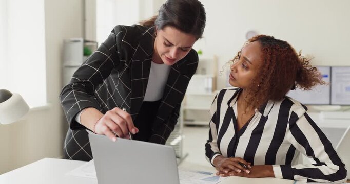 Businesswomen collaboration teamwork discussion with laptop. In a modern office they analyze data, planning strategy, align goals and offer mentorship during a meeting. Team plan in focus now.