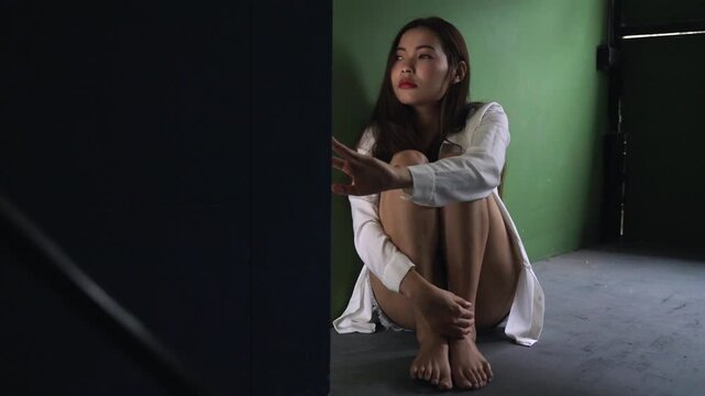 Unhappy Asian young woman sitting alone feeling sad lonely depressed worried upset in her room at home. The problem of female stress and waiting for mental health. Depression and loneliness concept. 