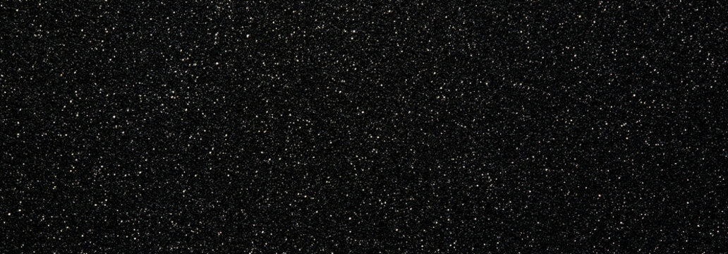 Abstract black background covered with small white sparkling dots.