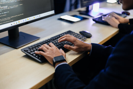 Developer typing code on computer keyboard in office, software engineer programming application backend on desktop monitor, IT specialist working on system database development