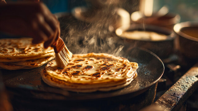 Traditional homemade one paratha cooking scene with layered flatbread sizzling on hot tawa, golden crispy edges and detailed flaky texture, warm sunlight entering cozy kitchen, close-up hands brushing