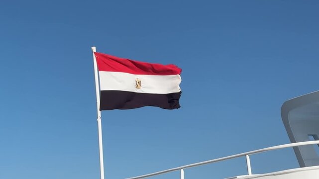 Egyptian flag on a ship against blue sky, sailing, national symbol, maritime pride, sunny voyage.