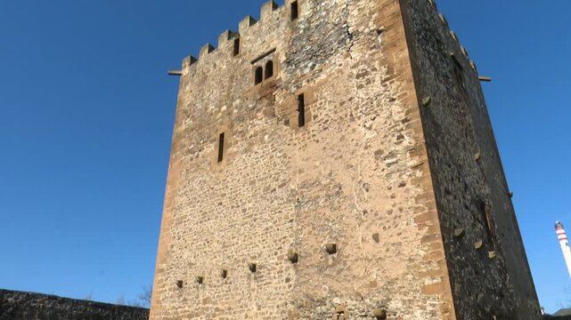 Tall medieval stone watchtower against clear blue sky exterior view tower