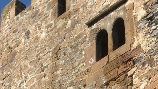 Close up of medieval castle stone wall with arched stone window architecture