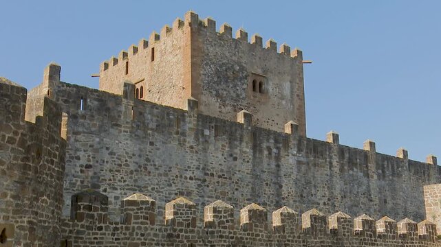 Battlements and stone tower of an ancient medieval castle fortification wall
