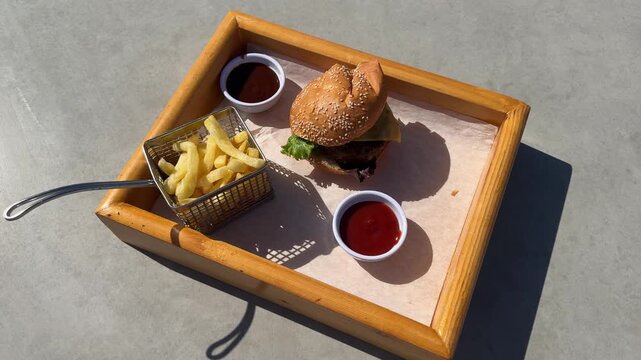 Cafe table with hamburger, french fries, and ketchup, casual dining, fast food meal ready to eat.