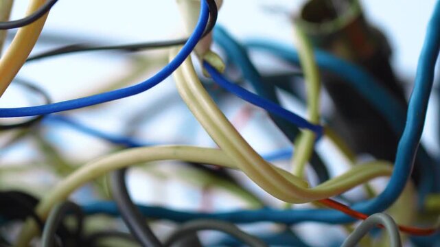 Old tangled ball of colorful electric wires and cables on a white background
