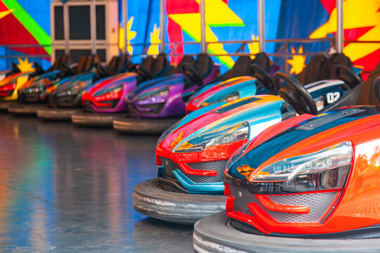 Bright bumper cars lined up at a vintage fairground autodrom arena amusement park close up
