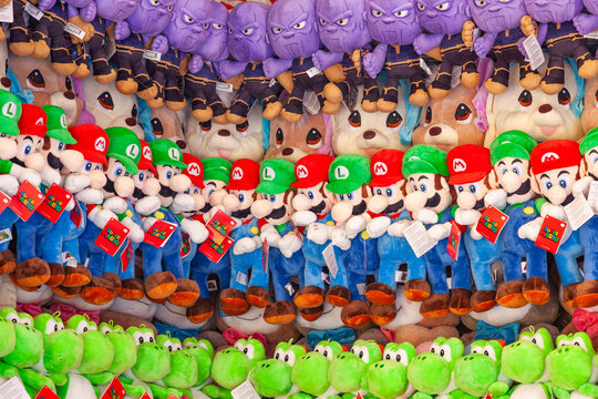 Frankfurt am Main, Germany - 01.05.2025: Large collection of plush toys including Mario, Luigi, Yoshi and Thanos hanging at a carnival prize display