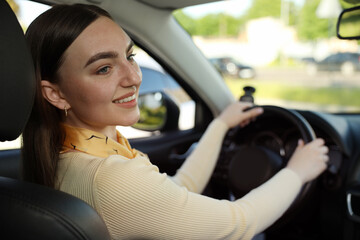 Naklejka premium Woman behind steering wheel of modern car