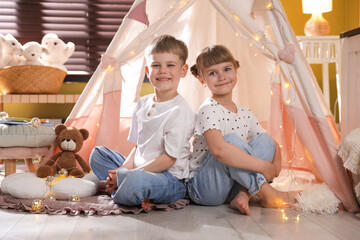 Little girl and boy near wigwam at home © New Africa