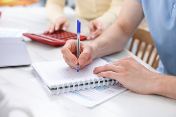 Fototapeta premium Couple planning their family budget at table indoors, closeup