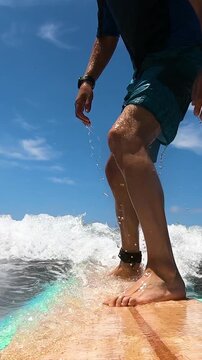Vertical slow motion POV from surfboard camera during a surf takeoff with dynamic wave motion and cinematic ocean action