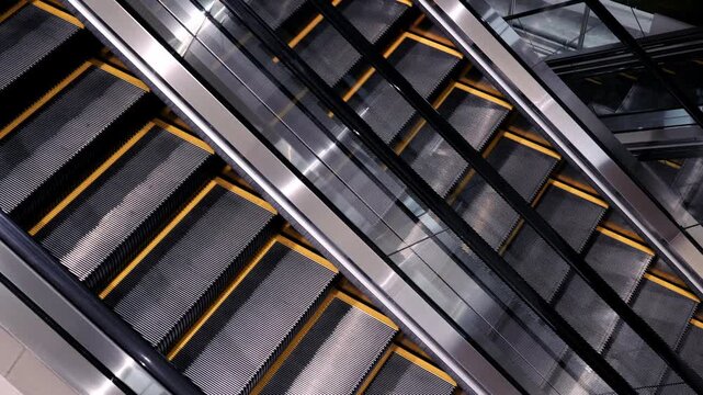 Escalator metal stairs modern architecture transportation moving indoors technology urban step handrail black yellow reflective industrial design pattern diagonal public facility safety