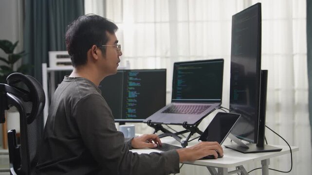 Focused Programmer Working on Multiple Screens in a Remote Office Setup to Enhance Productivity