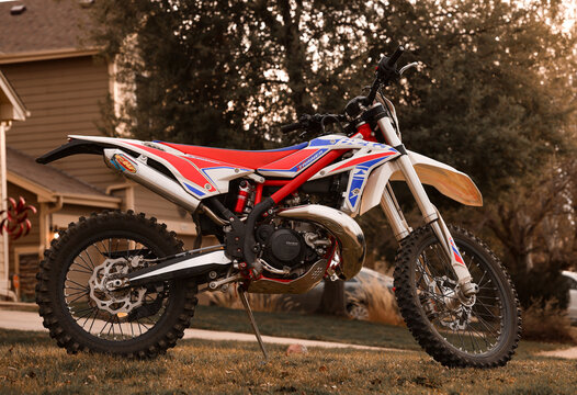2022 Beta 300cc XTrainer Dirt Bike Parked in a Residential Front Yard During Golden Hour, Side View