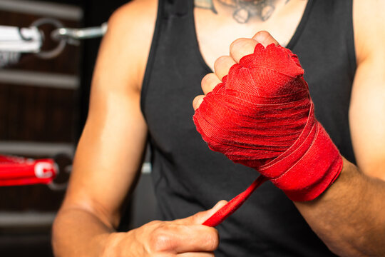 Close up wrapped boxer fist with blurred boxing ring in background