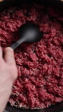 Crumbling Ground Beef with Silicone Spoon in Pan Close Up Vertical Top View
