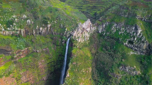 Aerial View of Tall Slender Waterfall Plunging Down Lsh Green Mountain Cliff