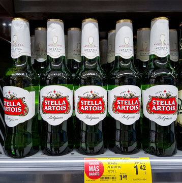 DENIA, SPAIN - January 31, 2026.Stella Artois beer bottles displayed on a supermarket shelf in Spain with a yellow price tag showing a promotion