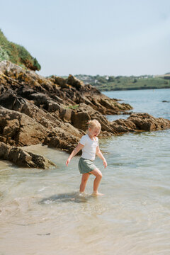 Young girl exploring along the shoreline of Irish bay