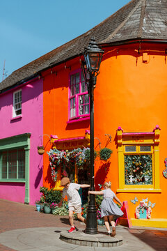 Children playing beside vibrant colorful storefronts in Kinsale Ireland
