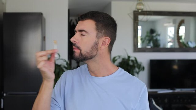 Man removing earwax tasting it with funny expression