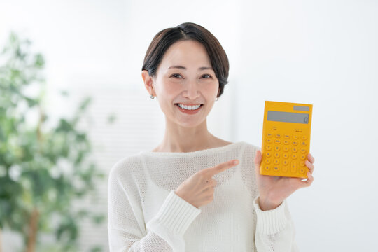 電卓を持って指差す女性