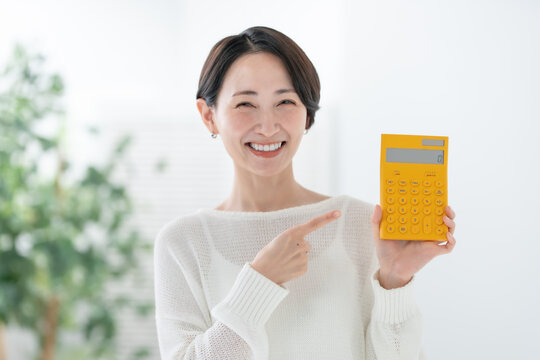 電卓を持って指差す女性