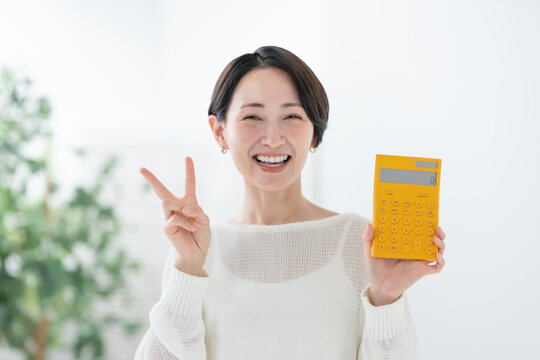 電卓を持つ女性　ピース