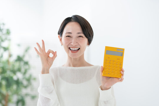 電卓を持つ女性 OK,オーケー,OKサイン,オーケーサイン,丸,了解,簡単,成功,安心,承諾,満足