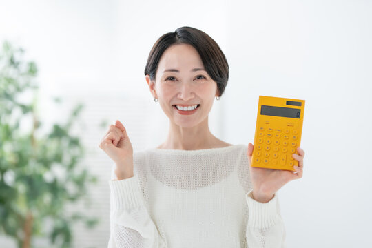 電卓を持つ女性　ガッツポーズ