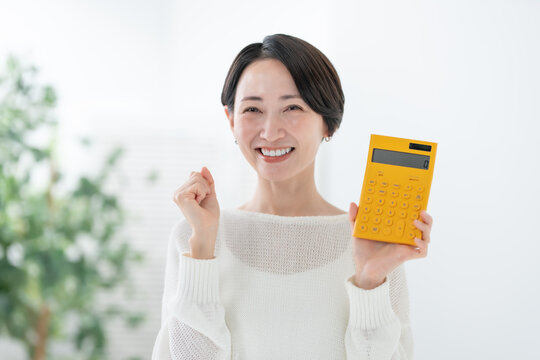 電卓を持つ女性　ガッツポーズ