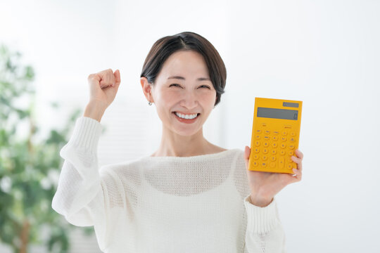 電卓を持つ女性　ガッツポーズ