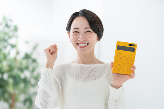 電卓を持つ女性　ガッツポーズ