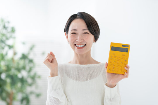 電卓を持つ女性　ガッツポーズ