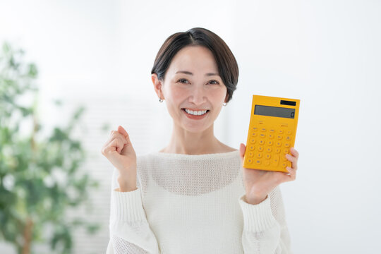 電卓を持つ女性　ガッツポーズ