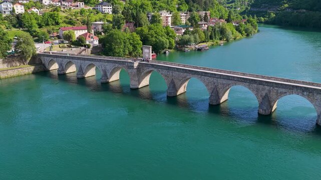 Drone footage of historic stone arches on Mehmed Pasha Sokolovic Bridge above the Drina River in Visegrad