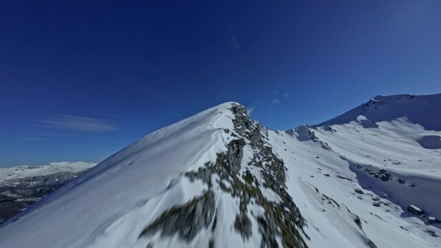 FPV Drone Shot Diving Fast Down Snowy Mountain Ridge lope