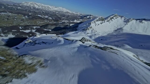 FPV Drone Shot Sweeping Close Over Snowy Mountain Sloe crest